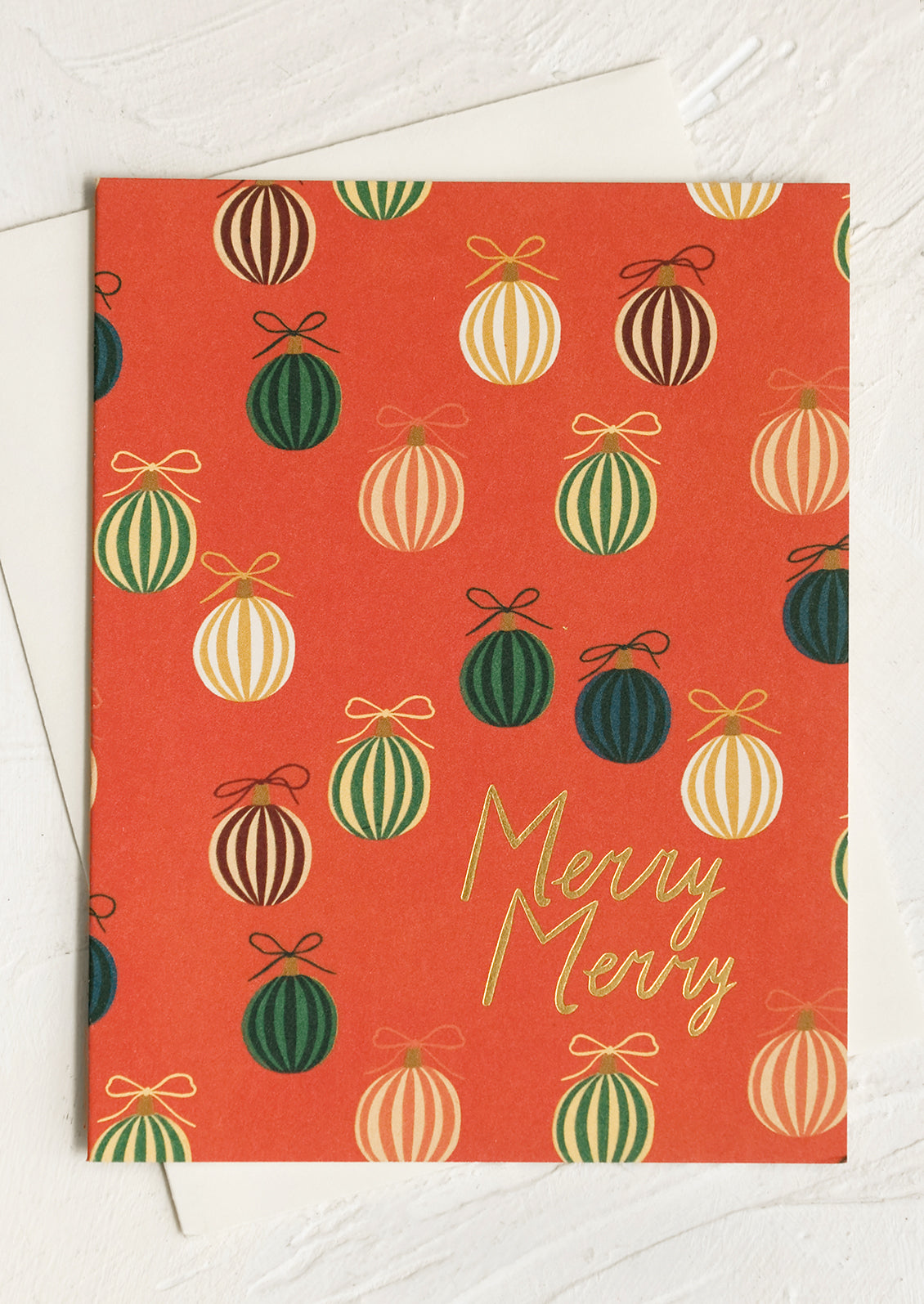 A set of red greeting cards with green ornament print, gold lettering reads "merry merry".