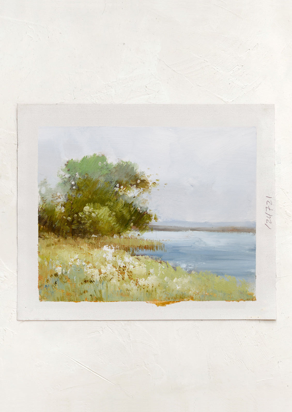 An original oil painting on unstretched canvas of a lake viewed from land.