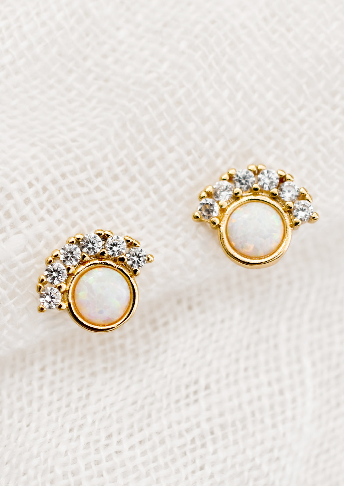 A pair of opal stud earrings with clear CZ pave detailing.