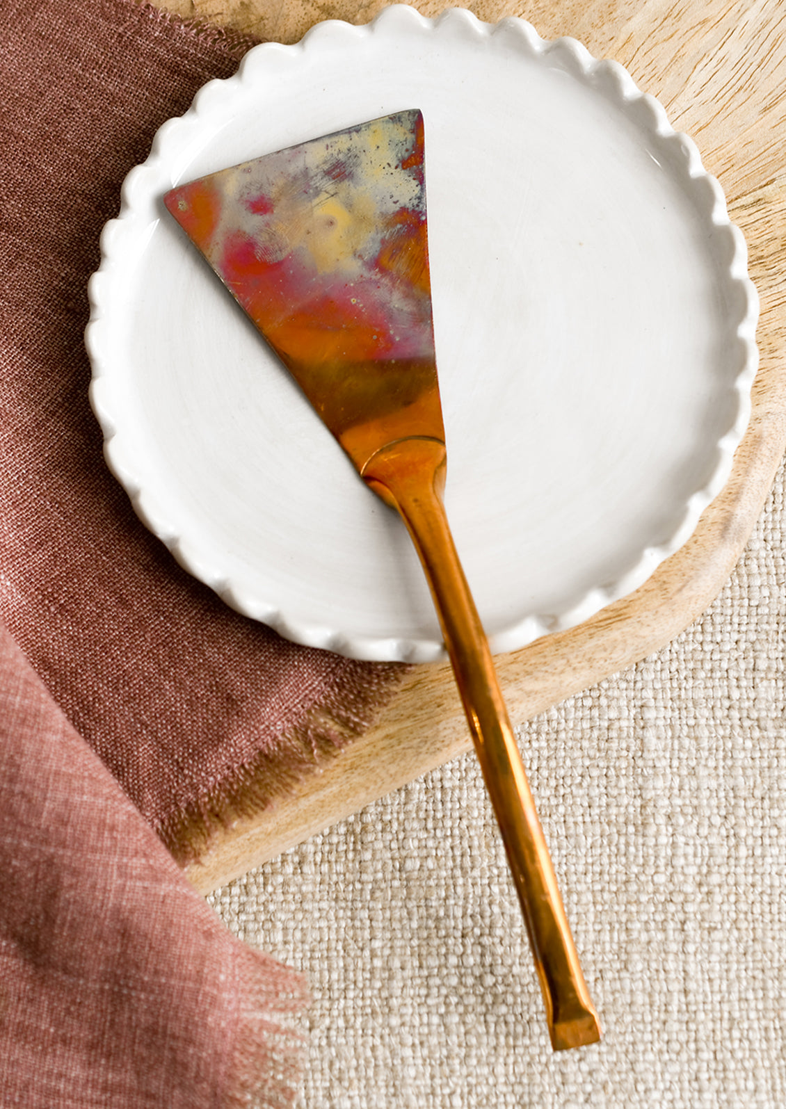 A copper metal serving spatula with oxidized finish.