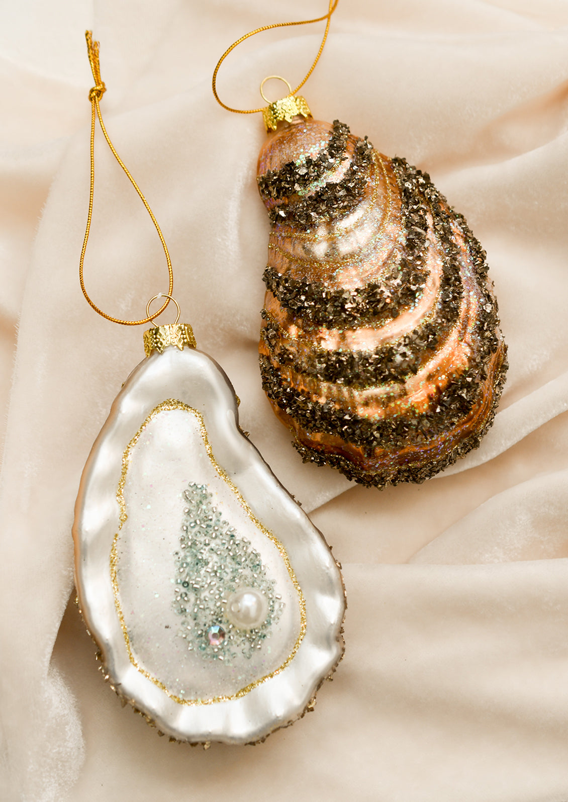 Glass oyster half shell ornaments with pearl detail.