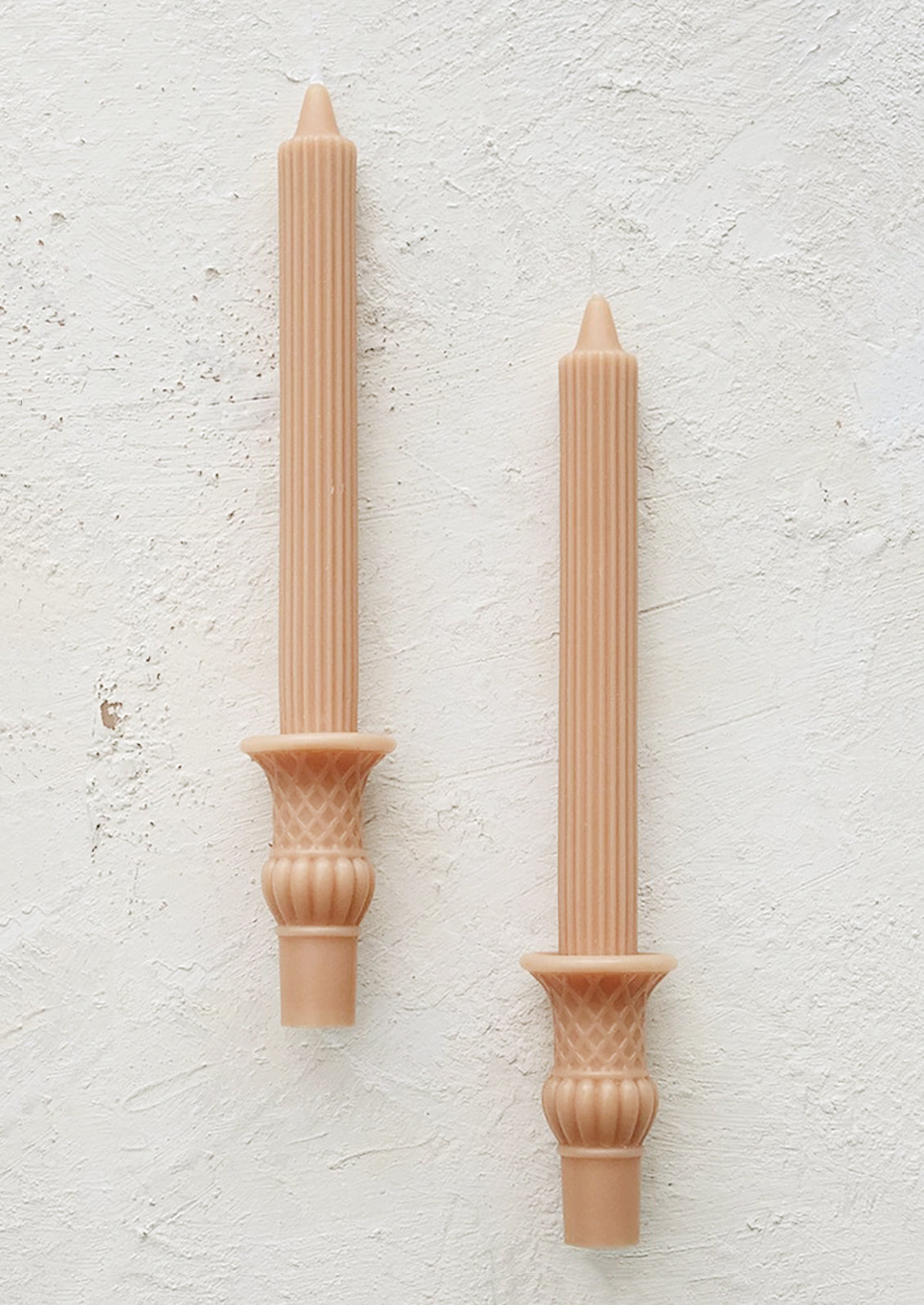 A pair of urn shaped taper candles in nectar color.