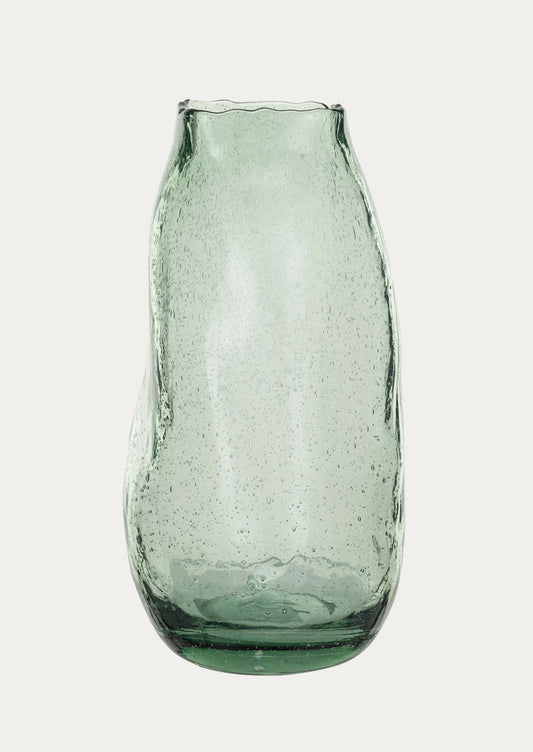 An asymmetrical glass vase in recycled green tinted glass with bubbles.