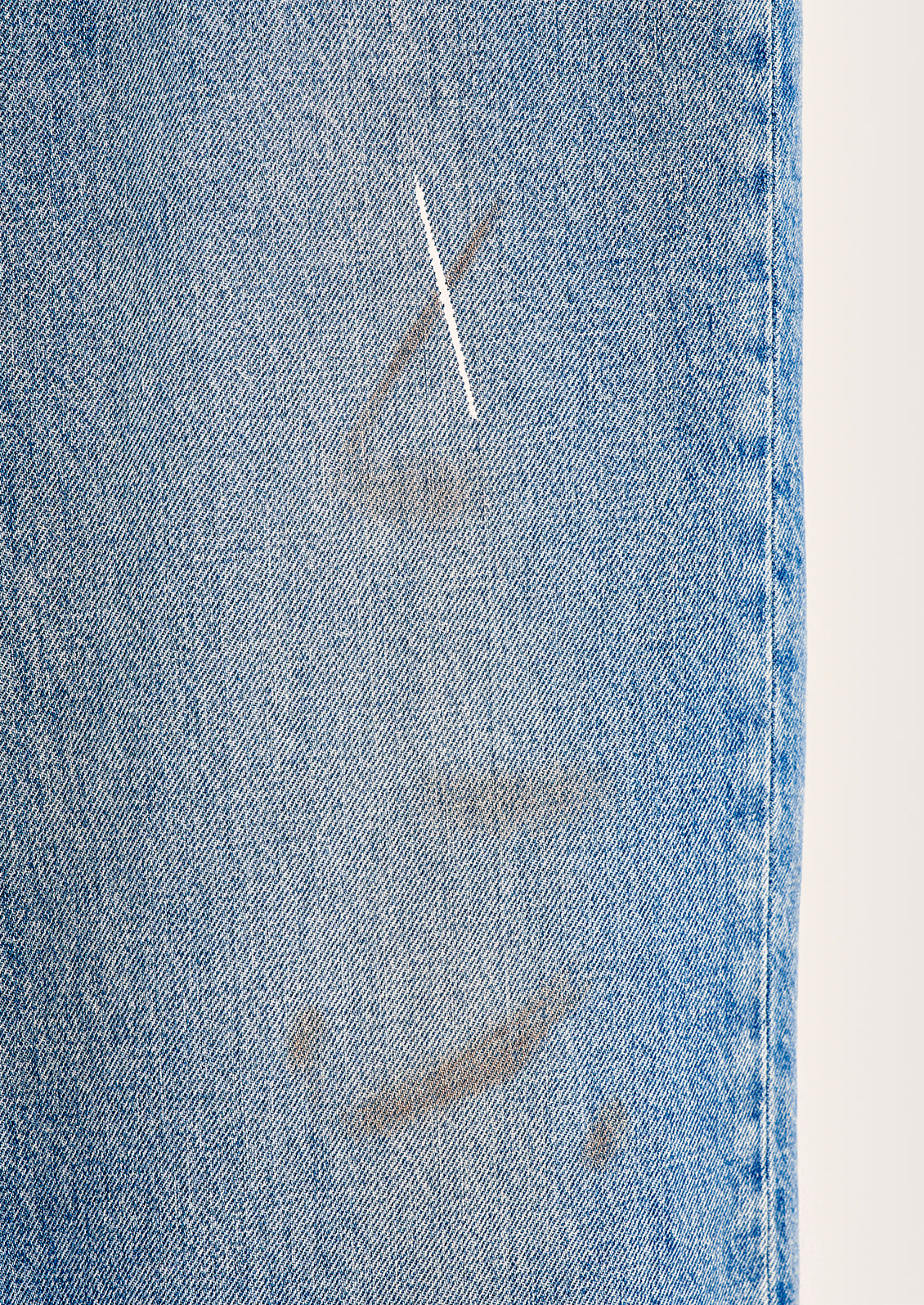 Distressed markings on denim jeans.