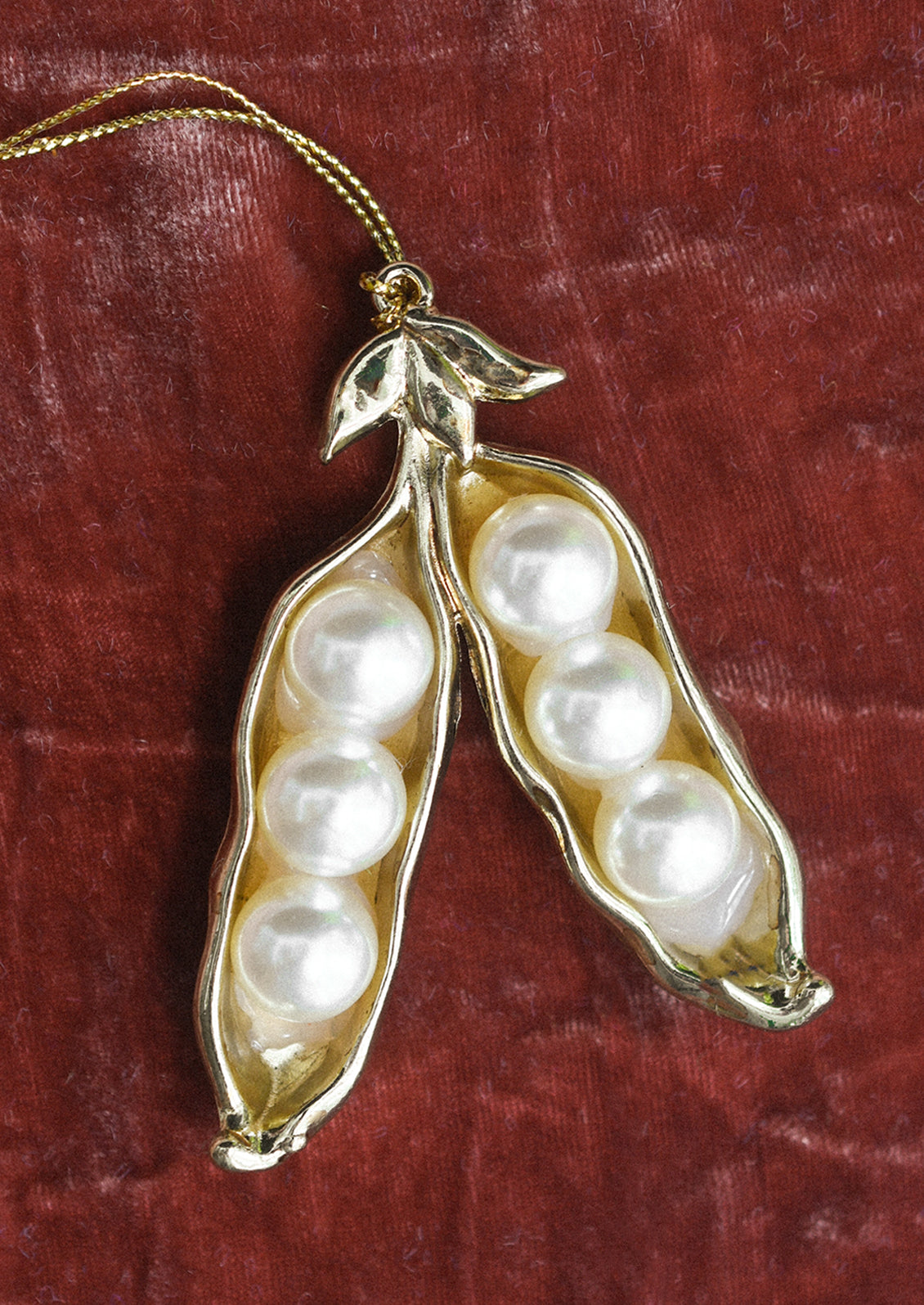 A gold sugar pea ornament with pearl "pods".