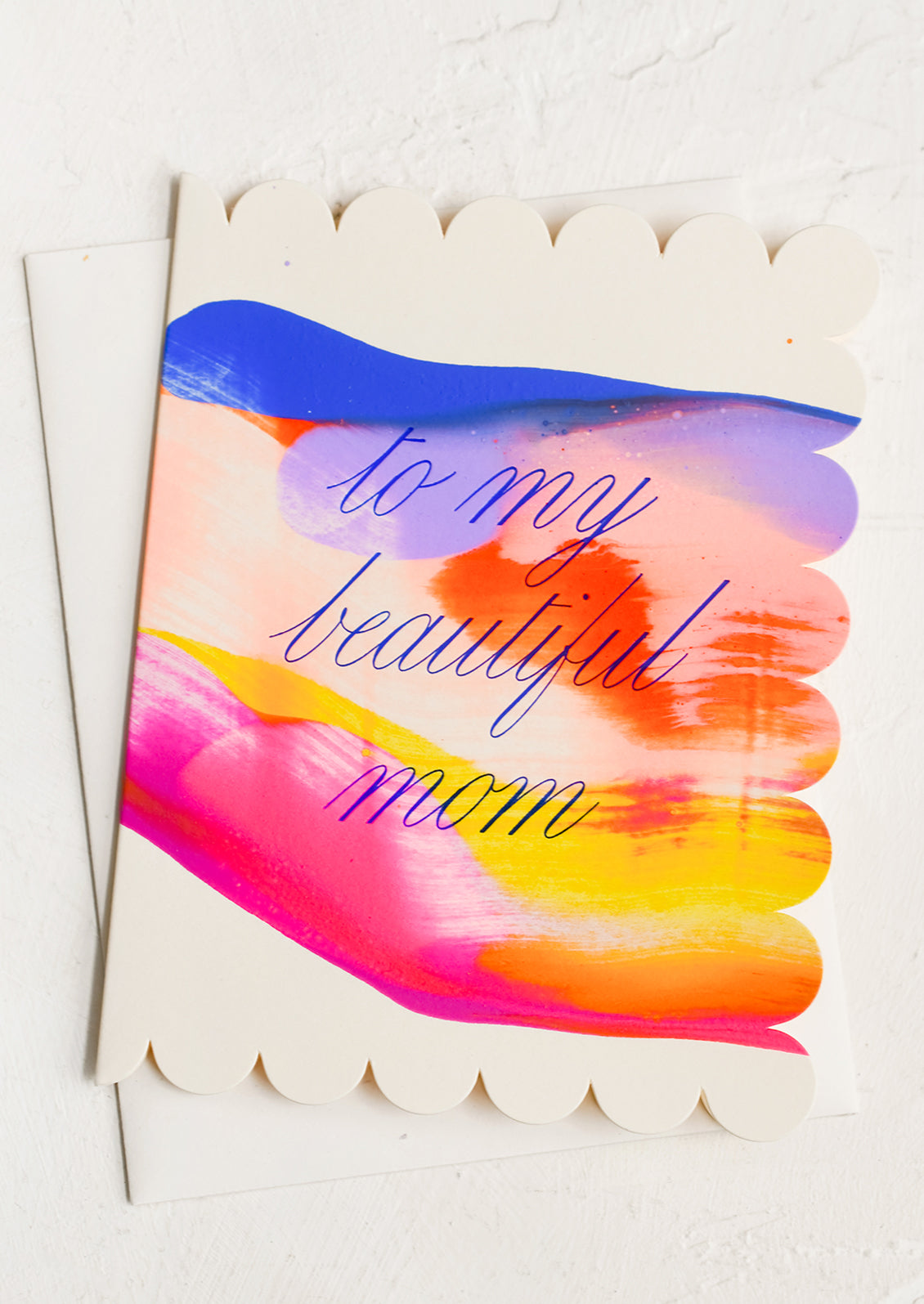 A scalloped edge card with bright colorful paint and text reading "To my beautiful mom".