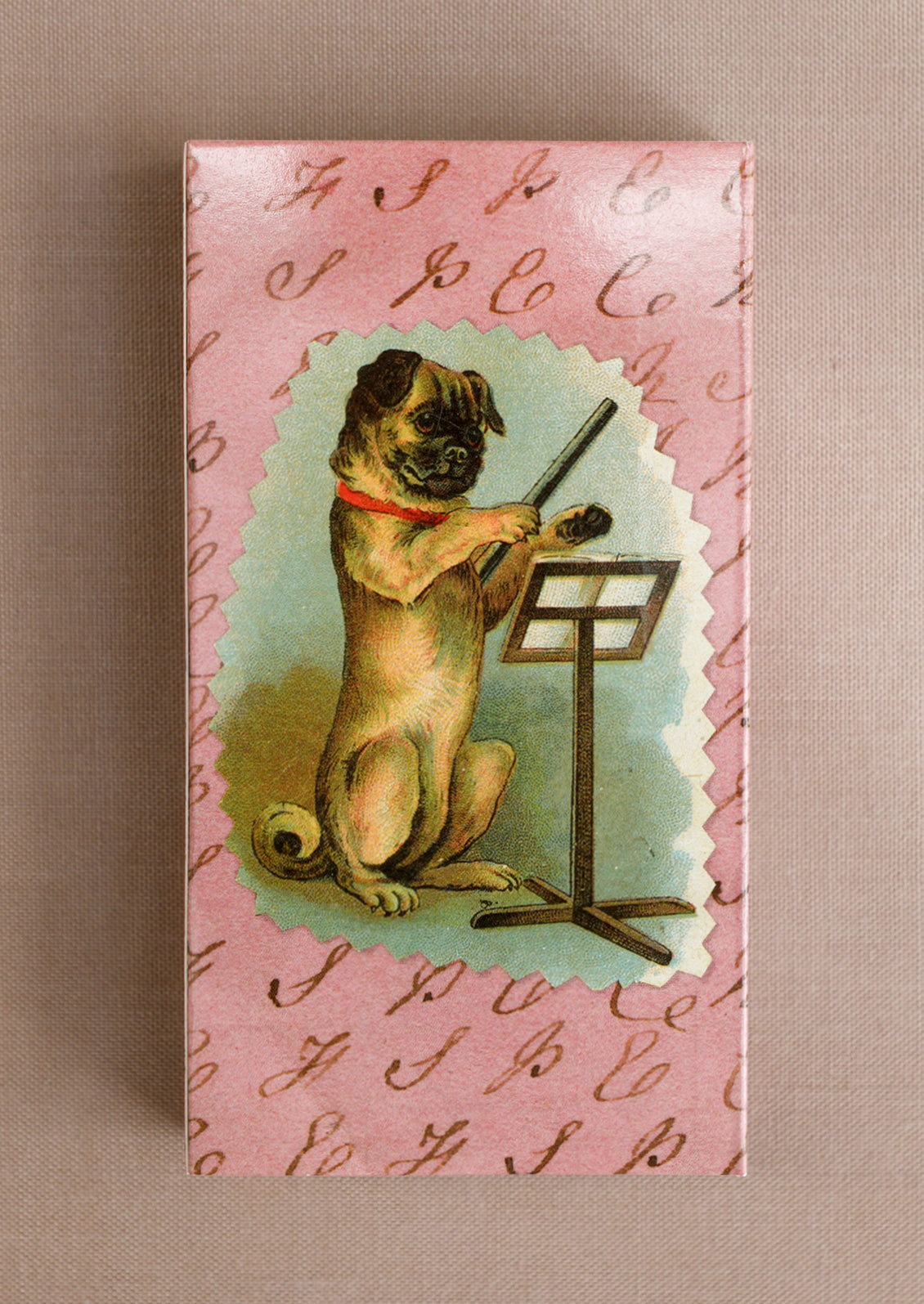 A matchbox with image of a pug conducting.