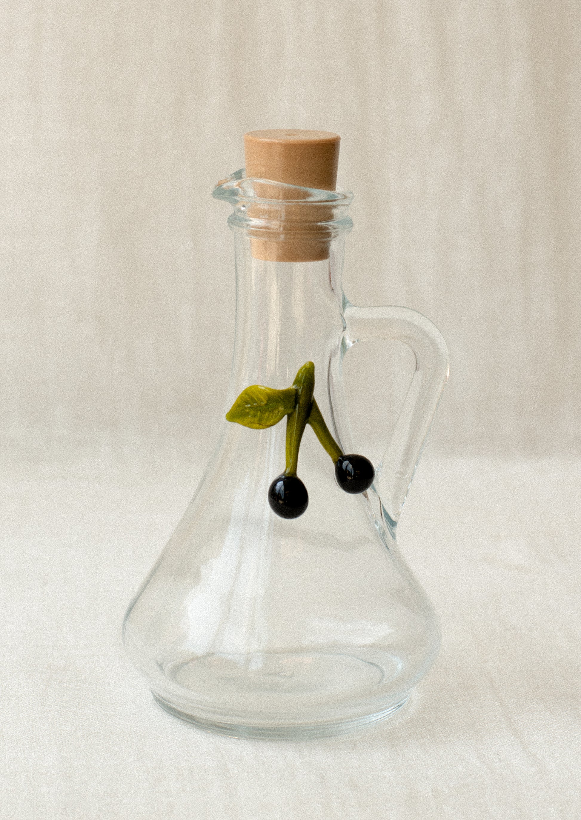 A clear glass cruet bottle with lampwork olive detail.