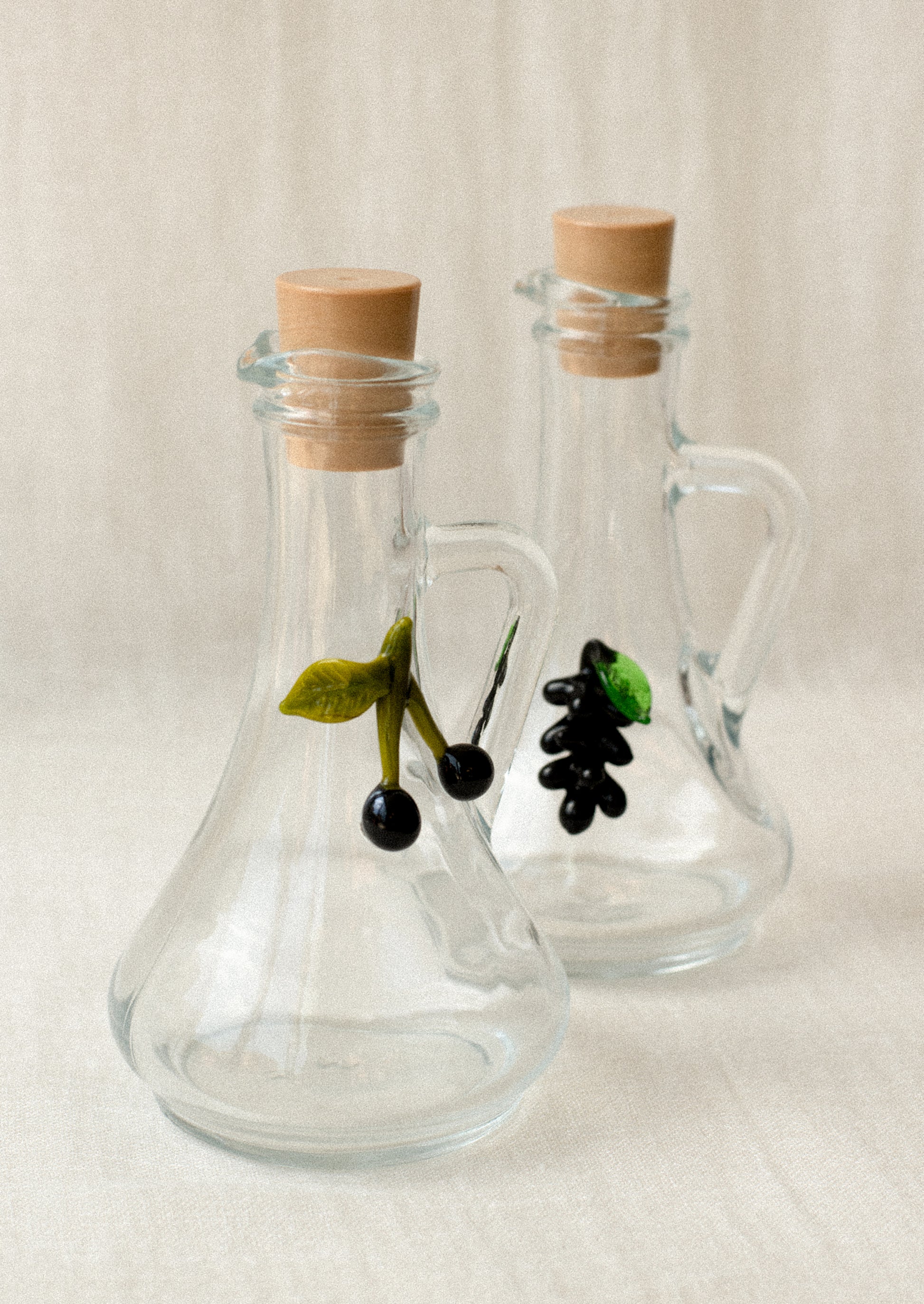 Clear glass cruet bottles with lampwork grape and olive detailing.