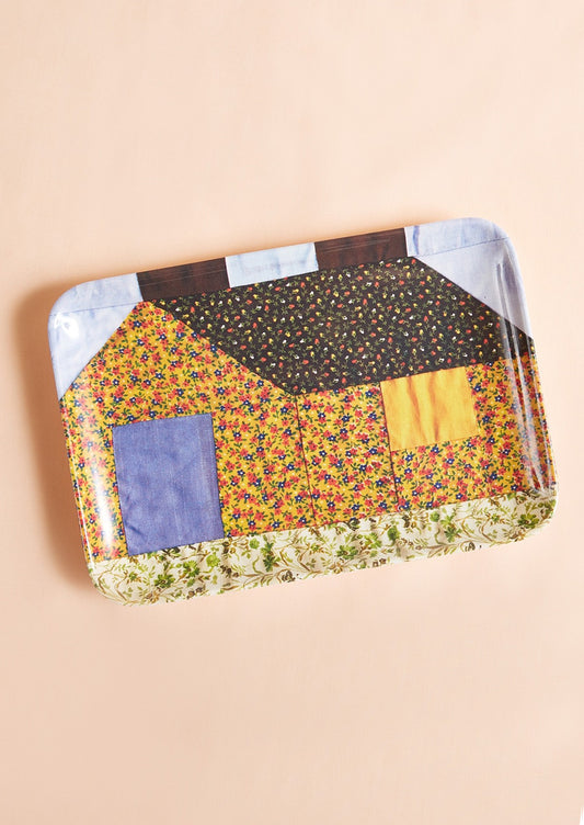 A patterned melamine tray in quilt pattern resembling a house.
