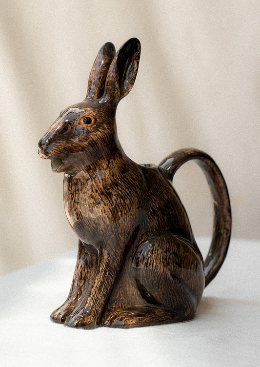 A brown ceramic pitcher in the realistic shape of a rabbit.