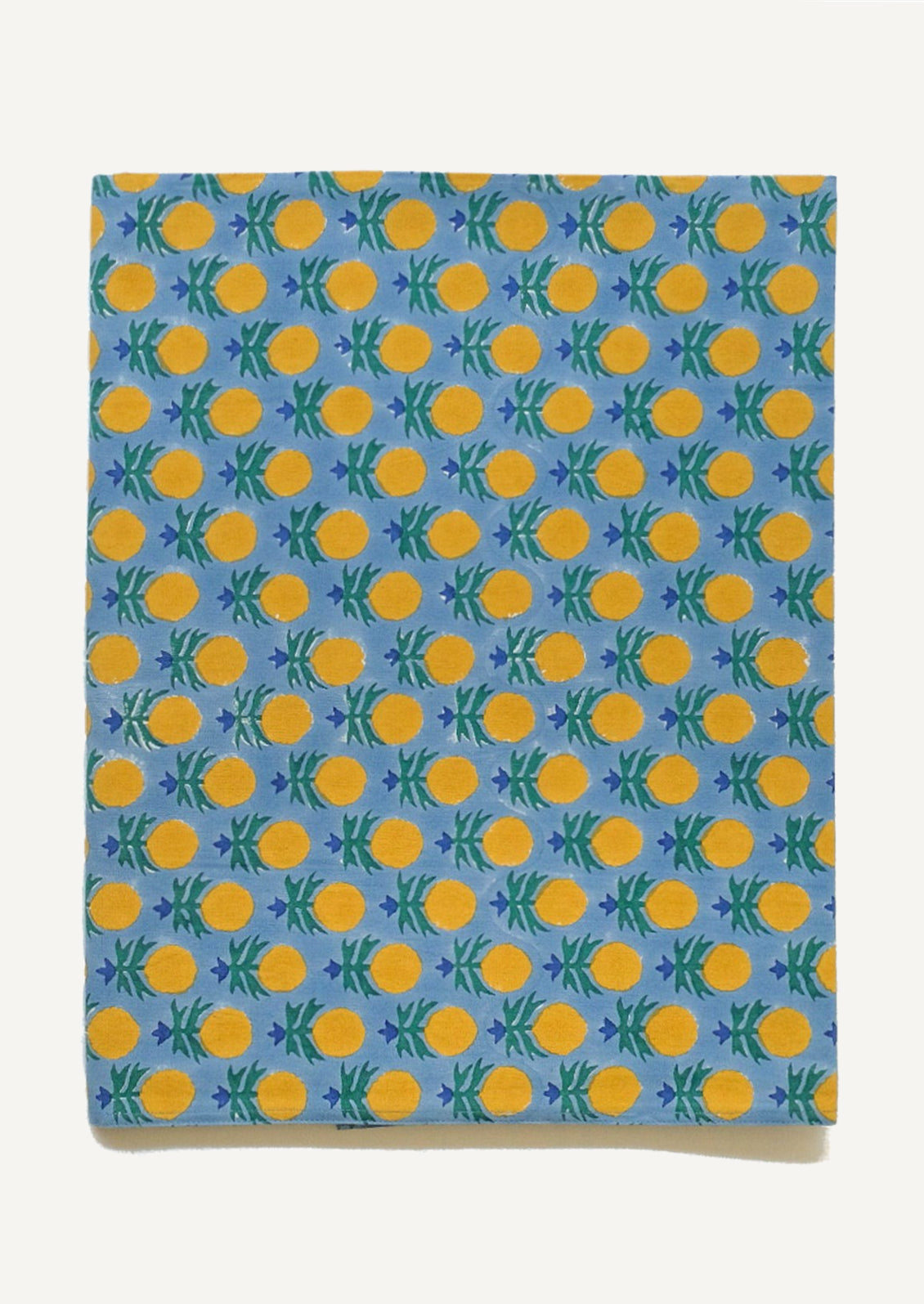 A blue tablecloth with yellow, blue and green block printed floral pattern.