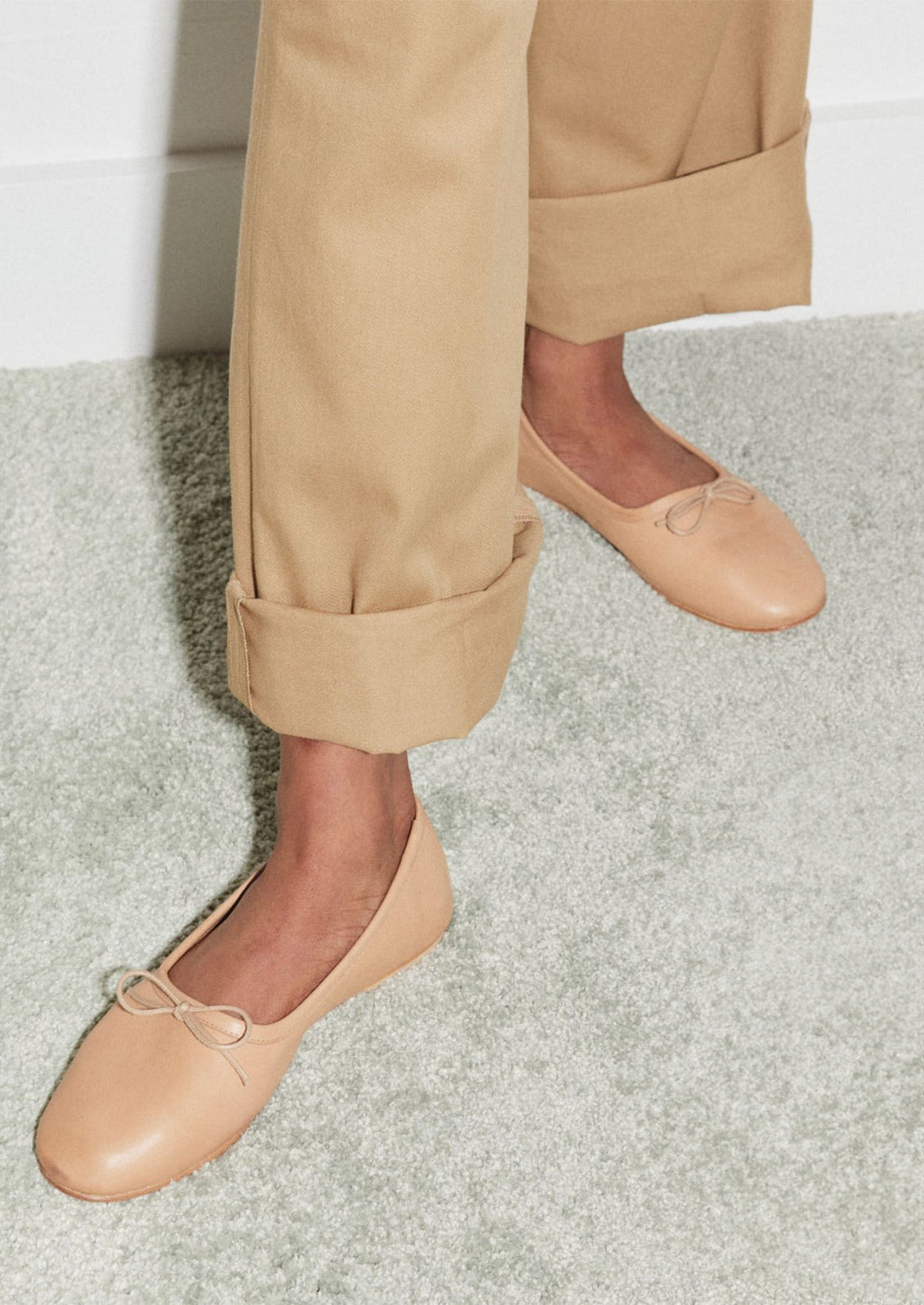 A pair of leather ballet flats with round toe in neutral tan leather.