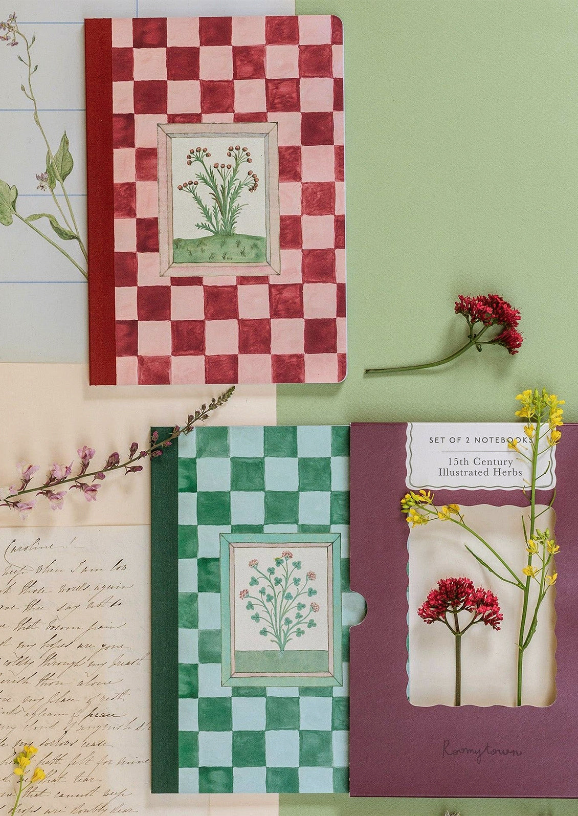 Notebooks in red and green checker prints with botanical illustrations.