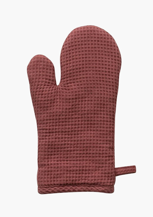 A waffle textured cotton oven mitt in rosewood.