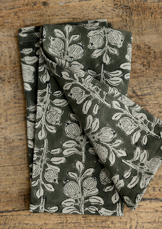 A set of cotton-linen napkins in dark green with natural floral print.