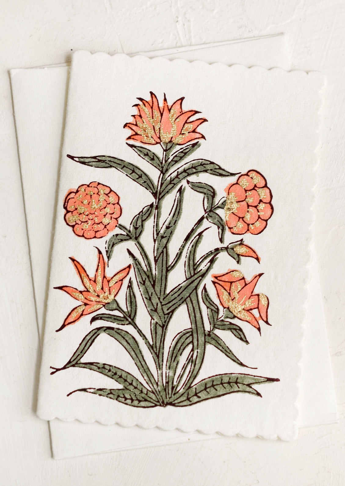 A block printed peach floral card with scalloped edges.