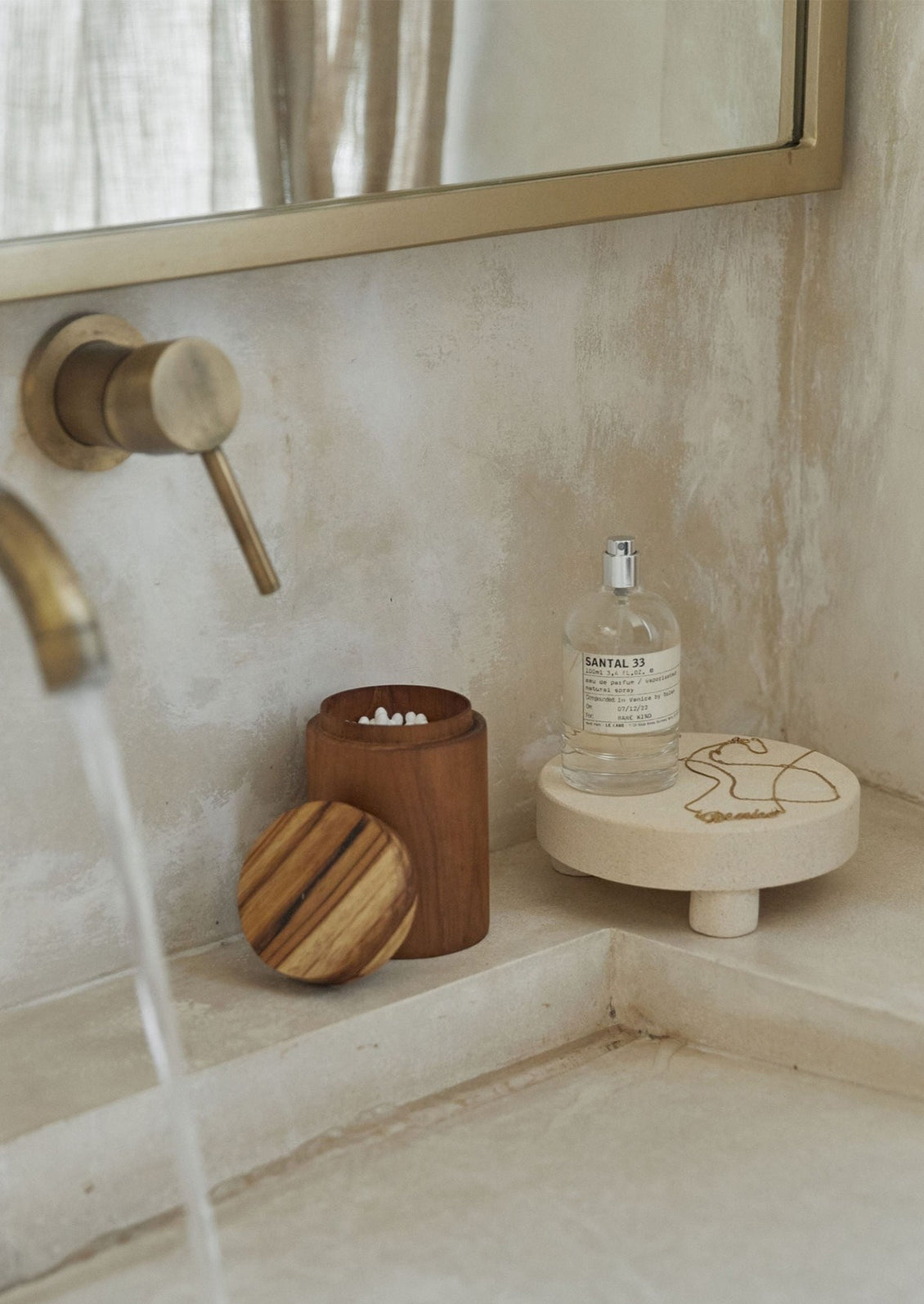 A tan sandstone round riser on a bathroom counter.