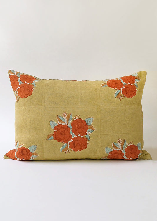 A muted mossy green lumbar pillow with rust, aqua and brown floral print.