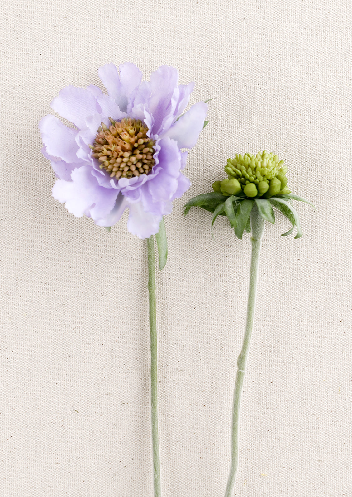 A faux scabiosa flower in lavender.