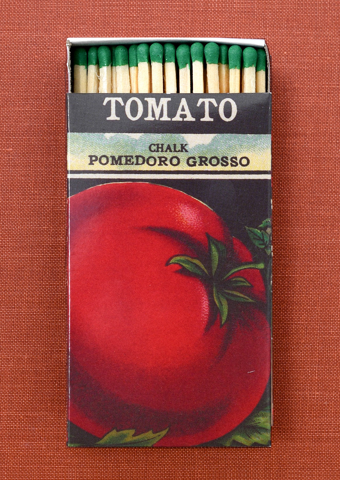 A matchbox with vintage inspired tomato seed box print.