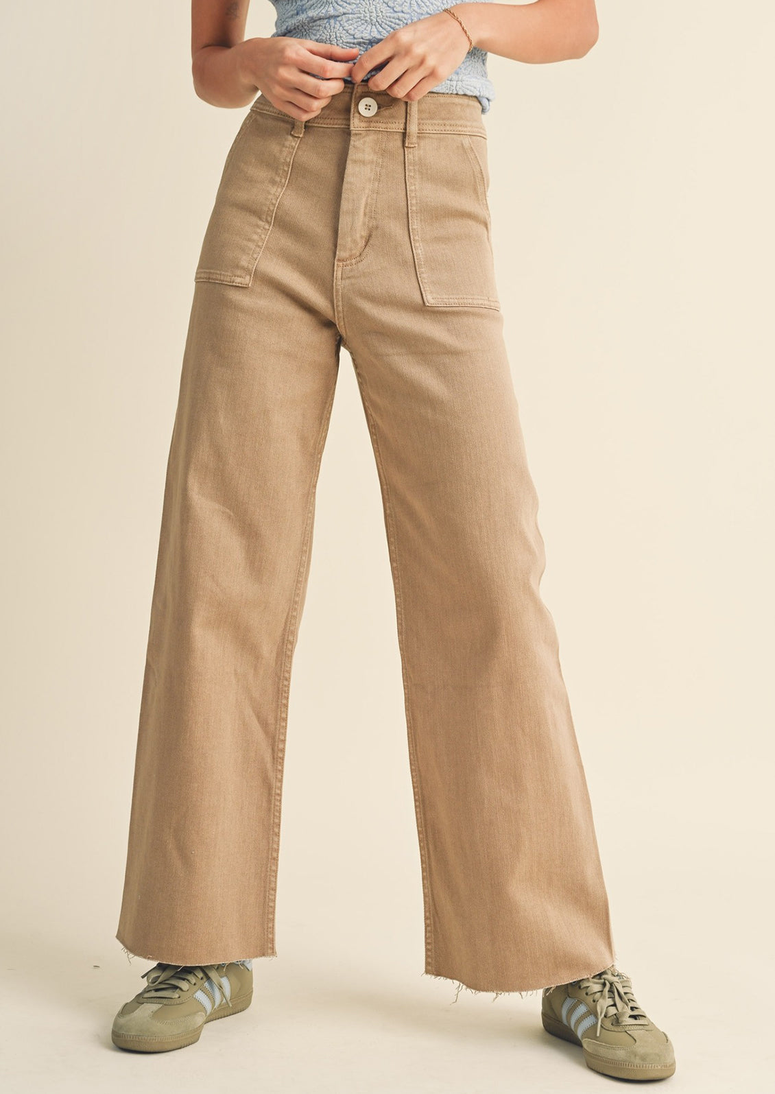A pair of light brown wide leg pants with front patch pockets.