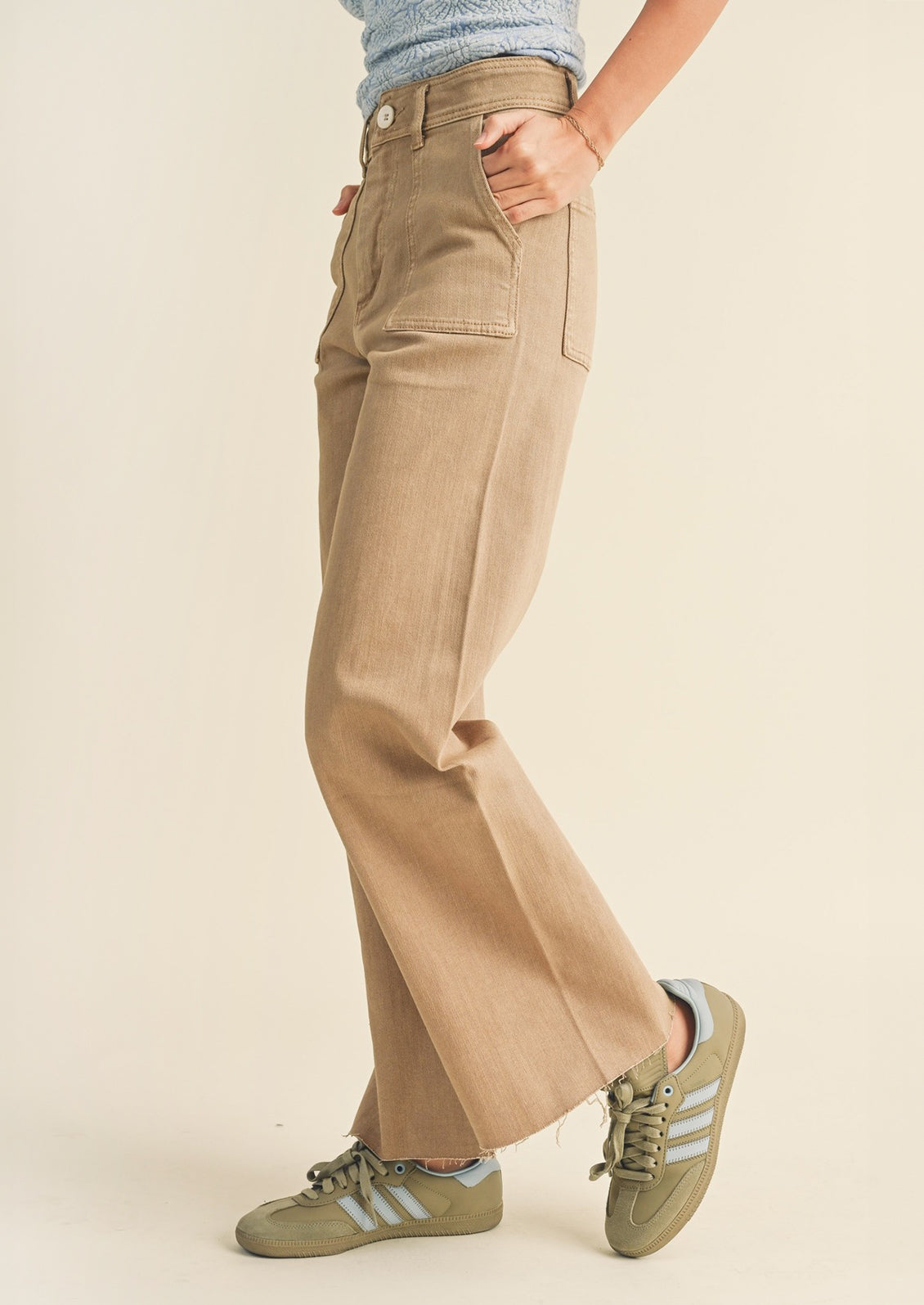 A pair of light brown wide leg pants with front patch pockets.