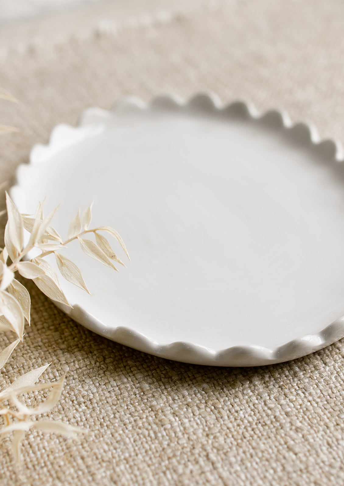 A white ceramic oval tray with scalloped edges.