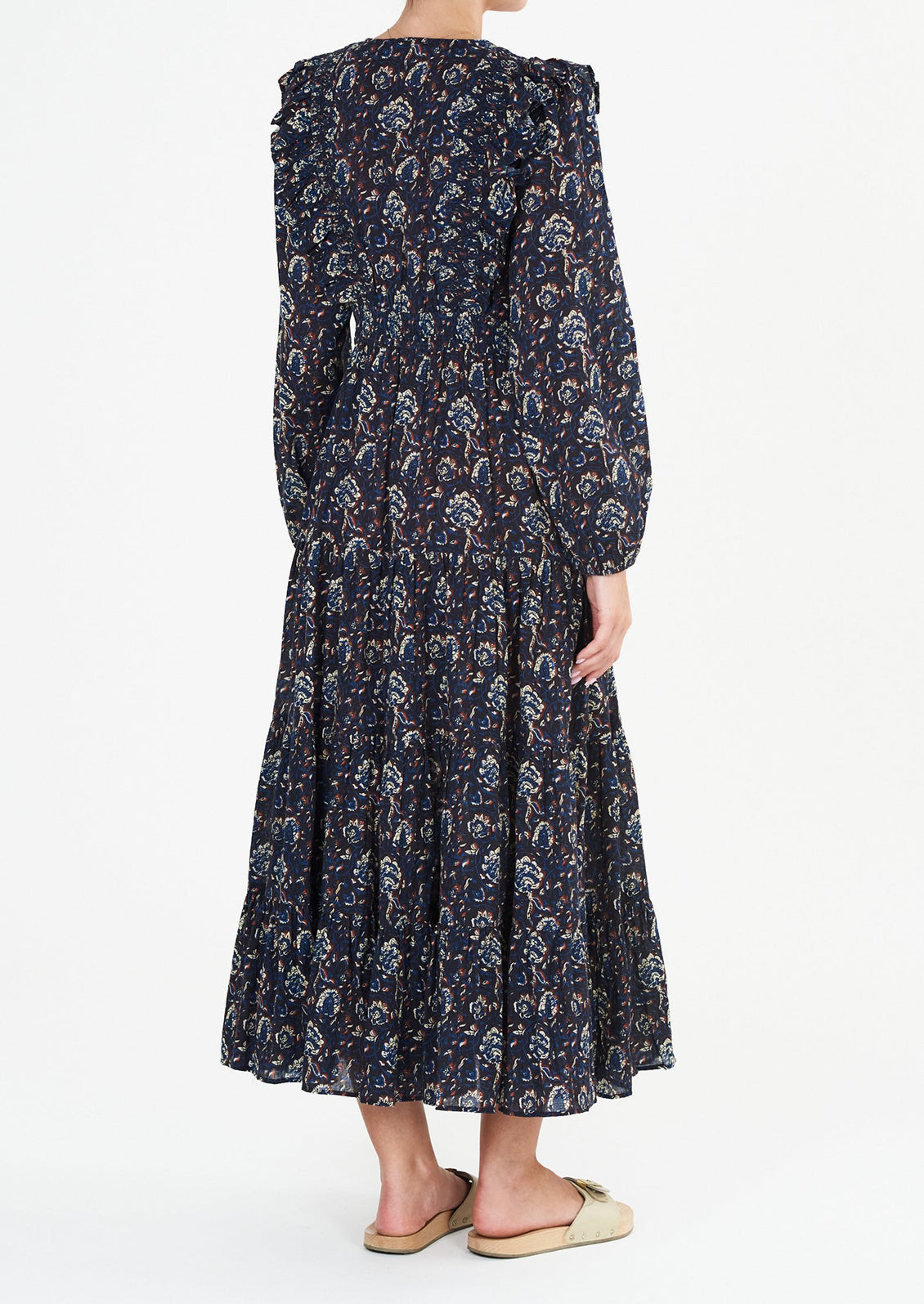 A long sleeve maxi dress with ruffled v-neck in black with blue, white and rust block print pattern.