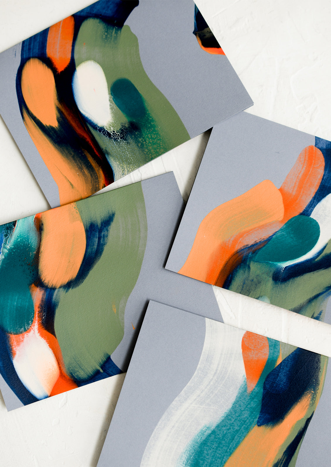 Grey cards with hand painted strokes of orange, green and blue.