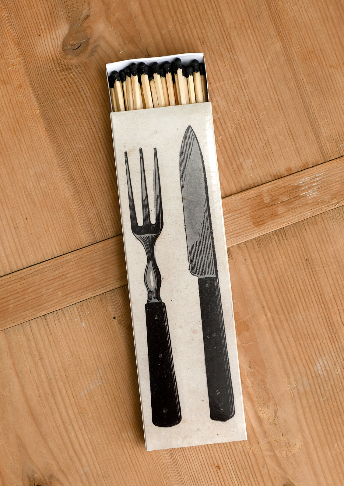 A long and skinny sliding matchbox with cutlery print.