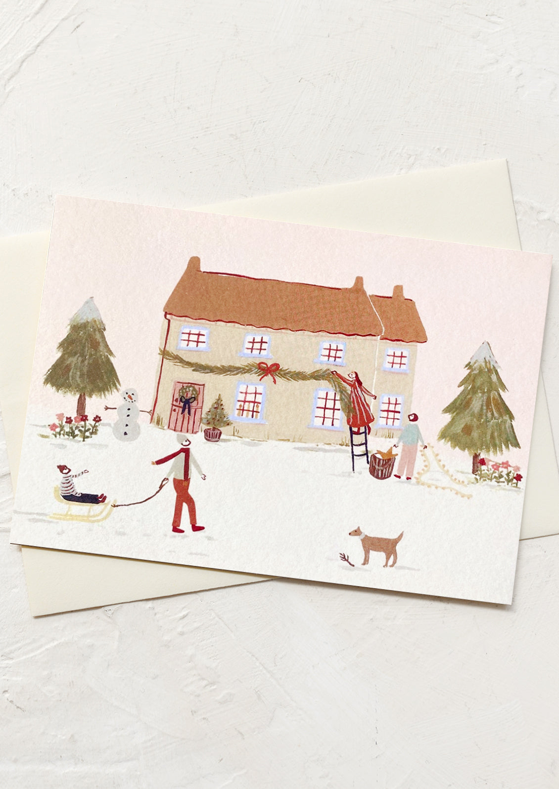 A greeting card with illustration of people decorating a house for the holidays.