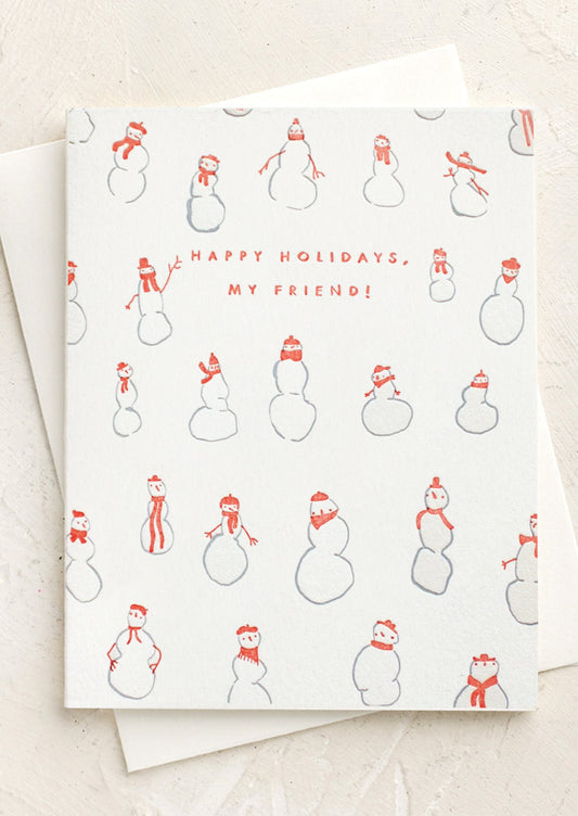 A letterpress card with images of snowman wearing scarves and hats, text reads "Happy Holidays, My Friend!".