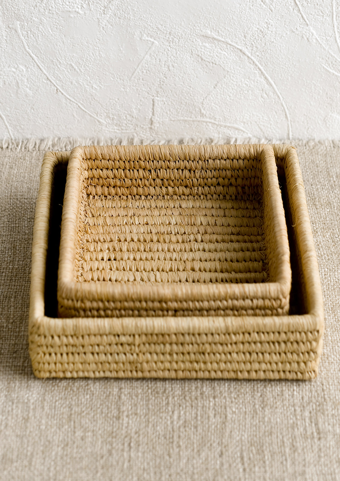 Square nesting raffia catchall baskets.