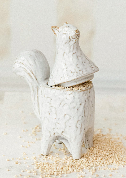 A ceramic jar in the shape of a squirrel standing on two legs.