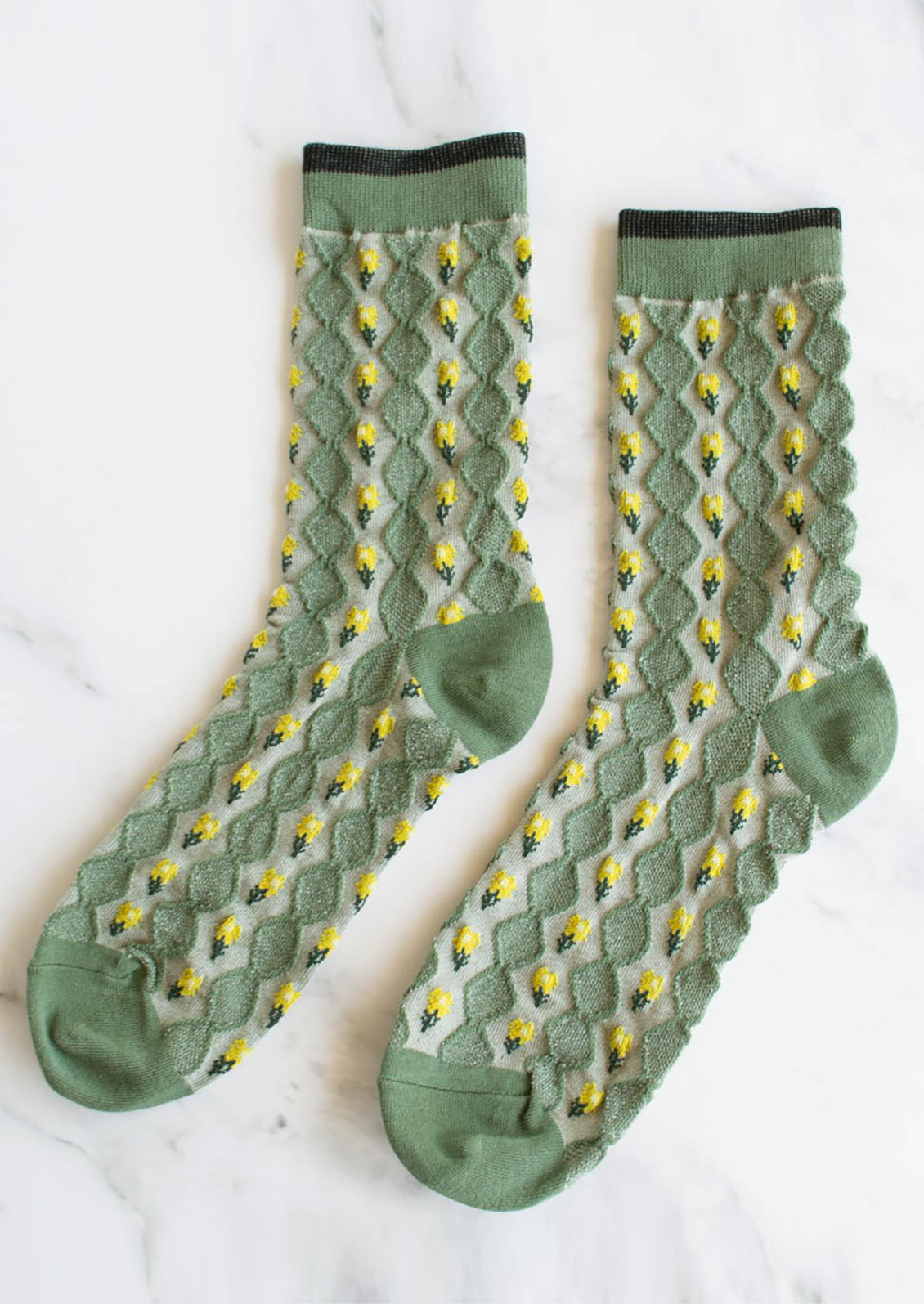 A pair of green socks with yellow flower vertical lines.