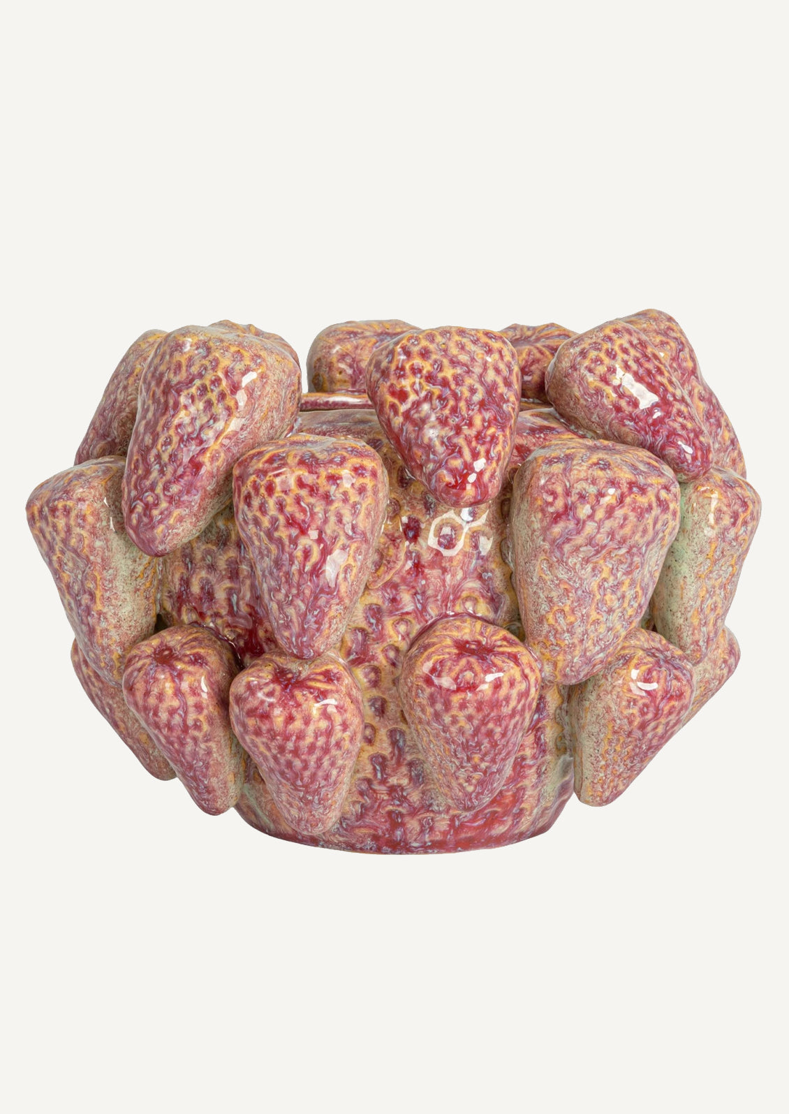 A ceramic planter with three dimensional strawberry shapes applied all over.