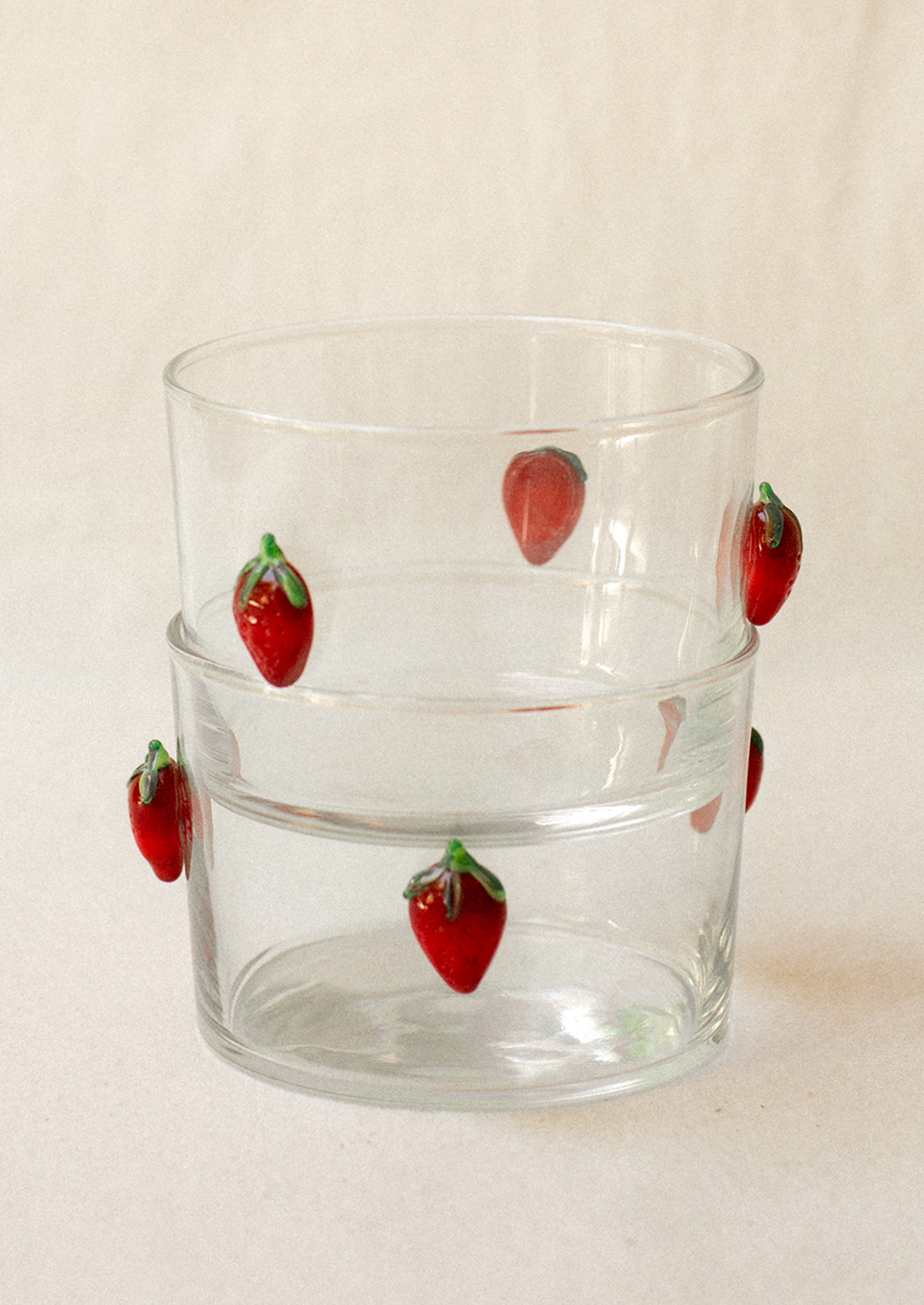 A clear glass short Spanish style wine glass with lampwork strawberry embellishment.