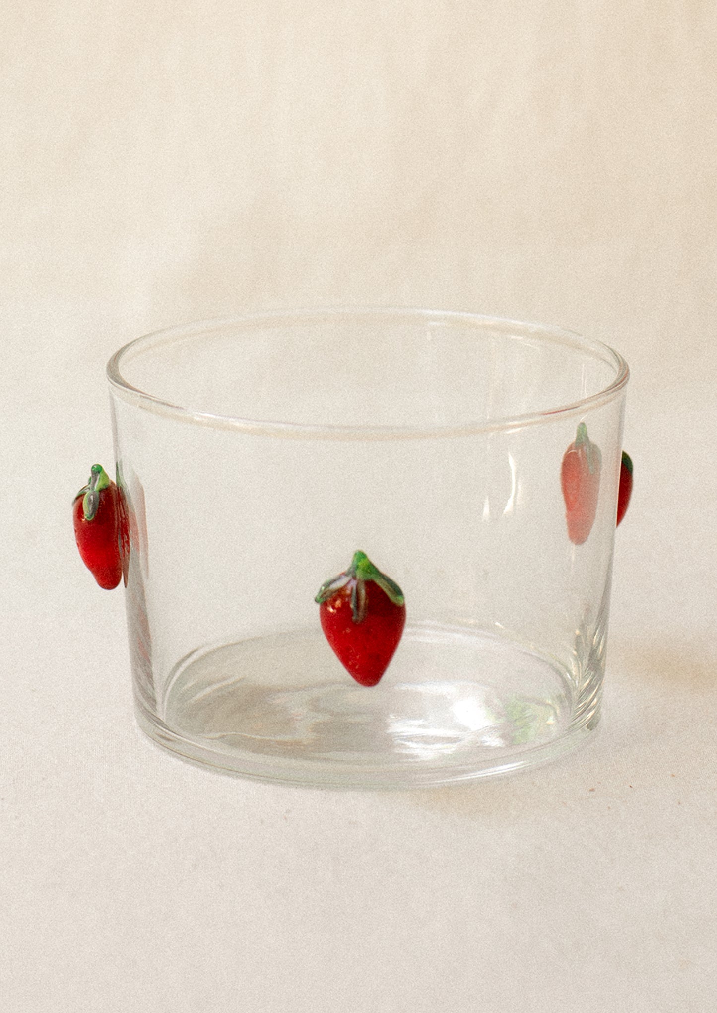 A clear glass short Spanish style wine glass with lampwork strawberry embellishment.