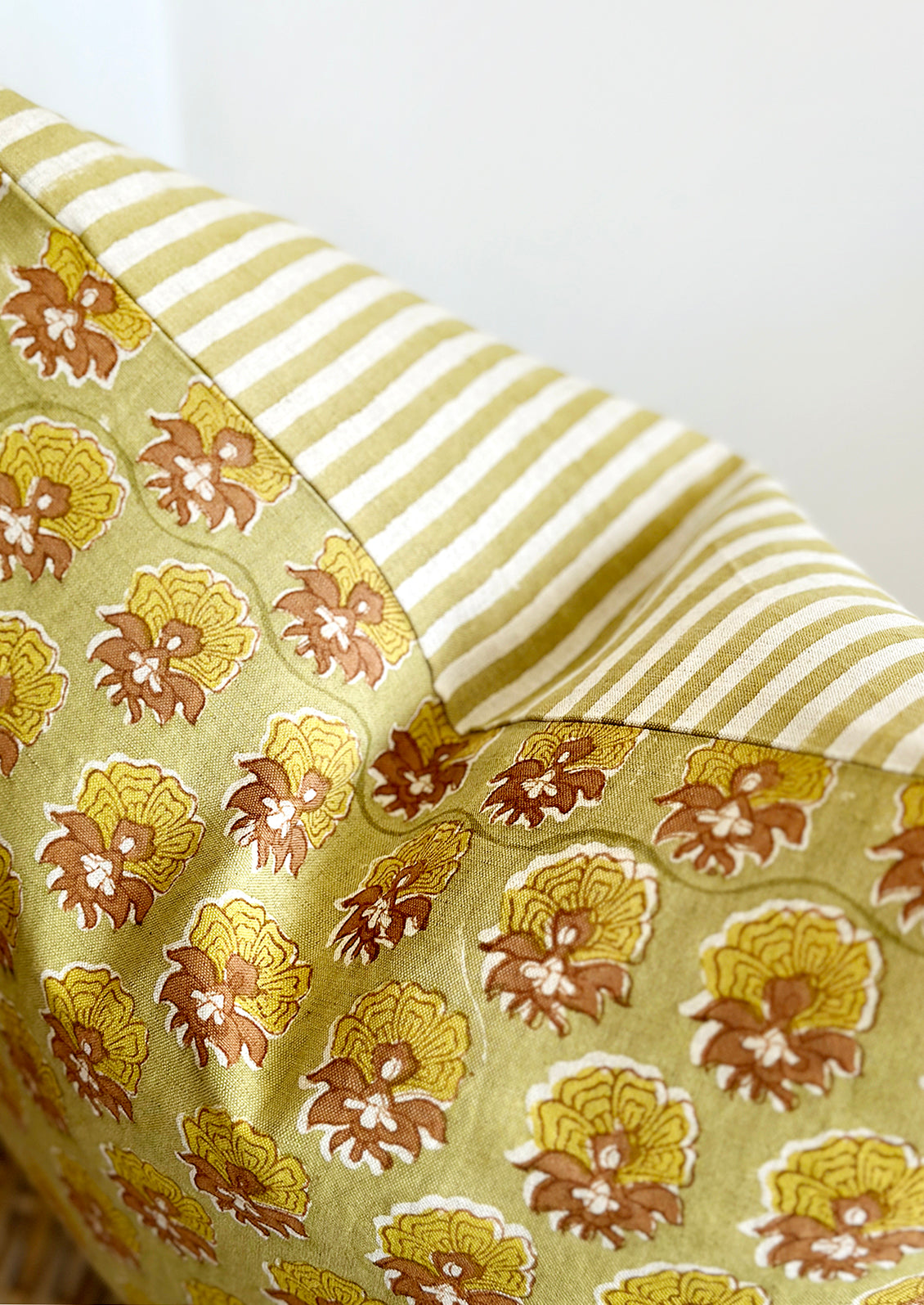 A striped block print pillow with floral print.