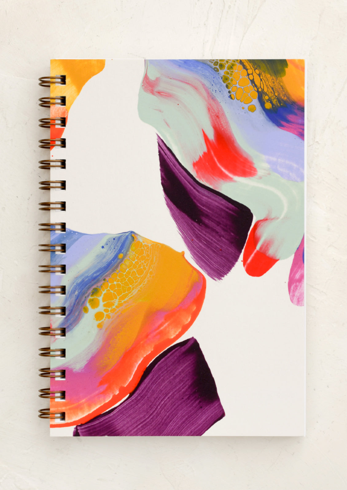 A spiral bound notebook with brightly painted cover.