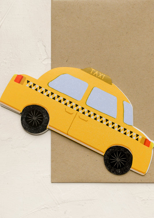 A diecut greeting card in shape of yellow taxi.