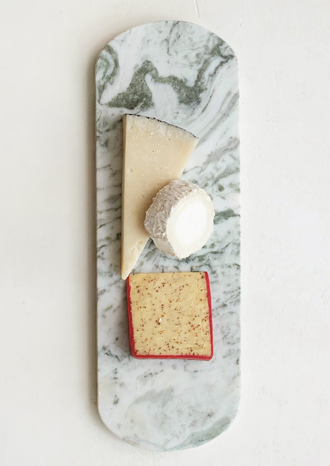 An elongated oval shaped serving platter in green and white marble.