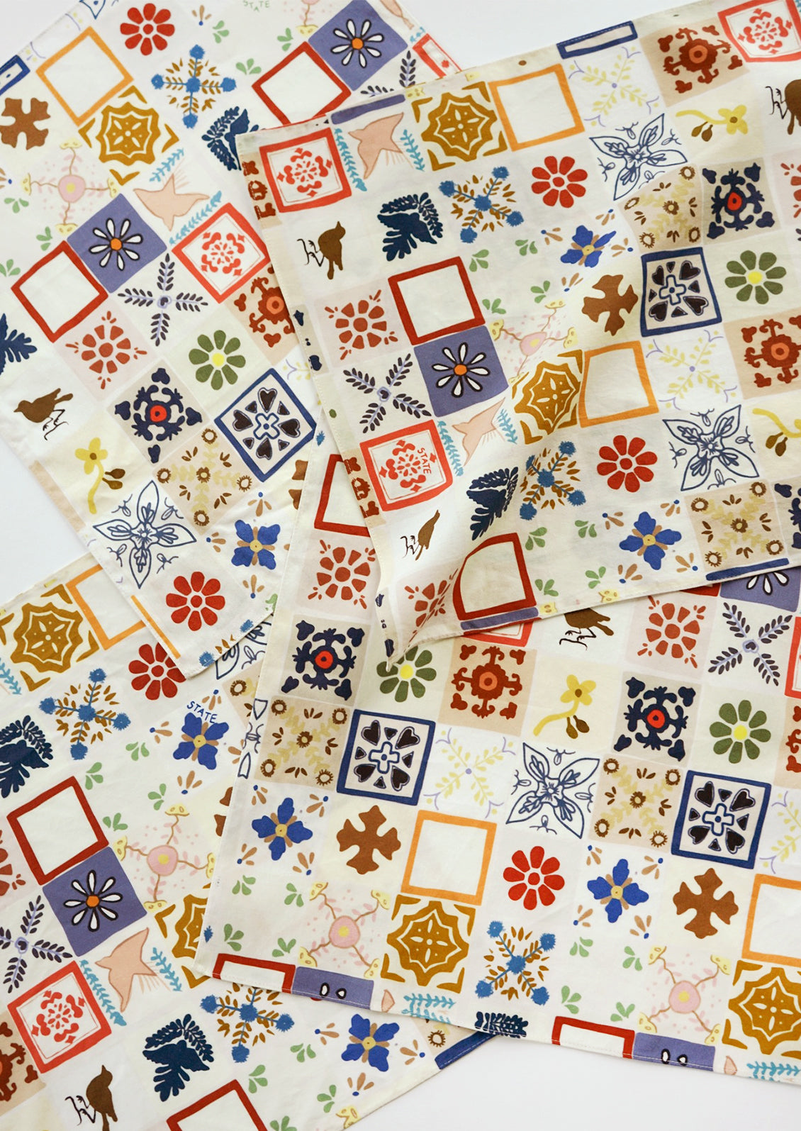 A set of four colorful, mixed tile print cloth napkins.