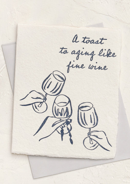 A greeting card with text reading "A toast to aging like a fine wine".