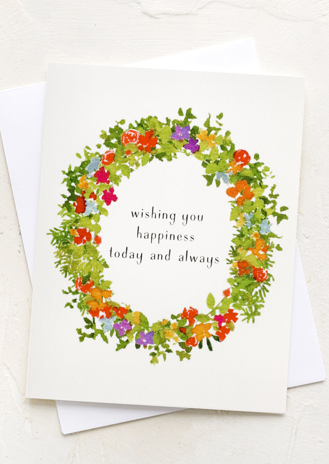 A floral wreath print card reading "wishing you happiness today and always".