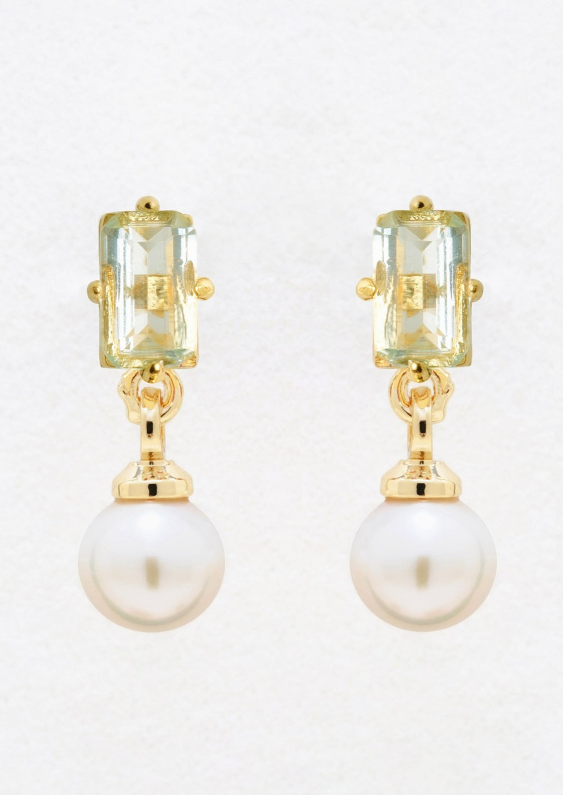 A pair of gold studs with baguette blue topaz and dangling pearl.