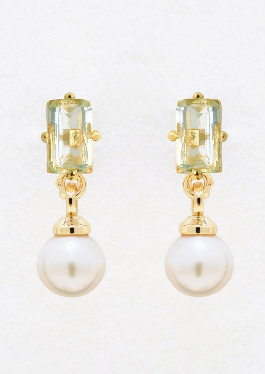 A pair of gold studs with baguette blue topaz and dangling pearl.