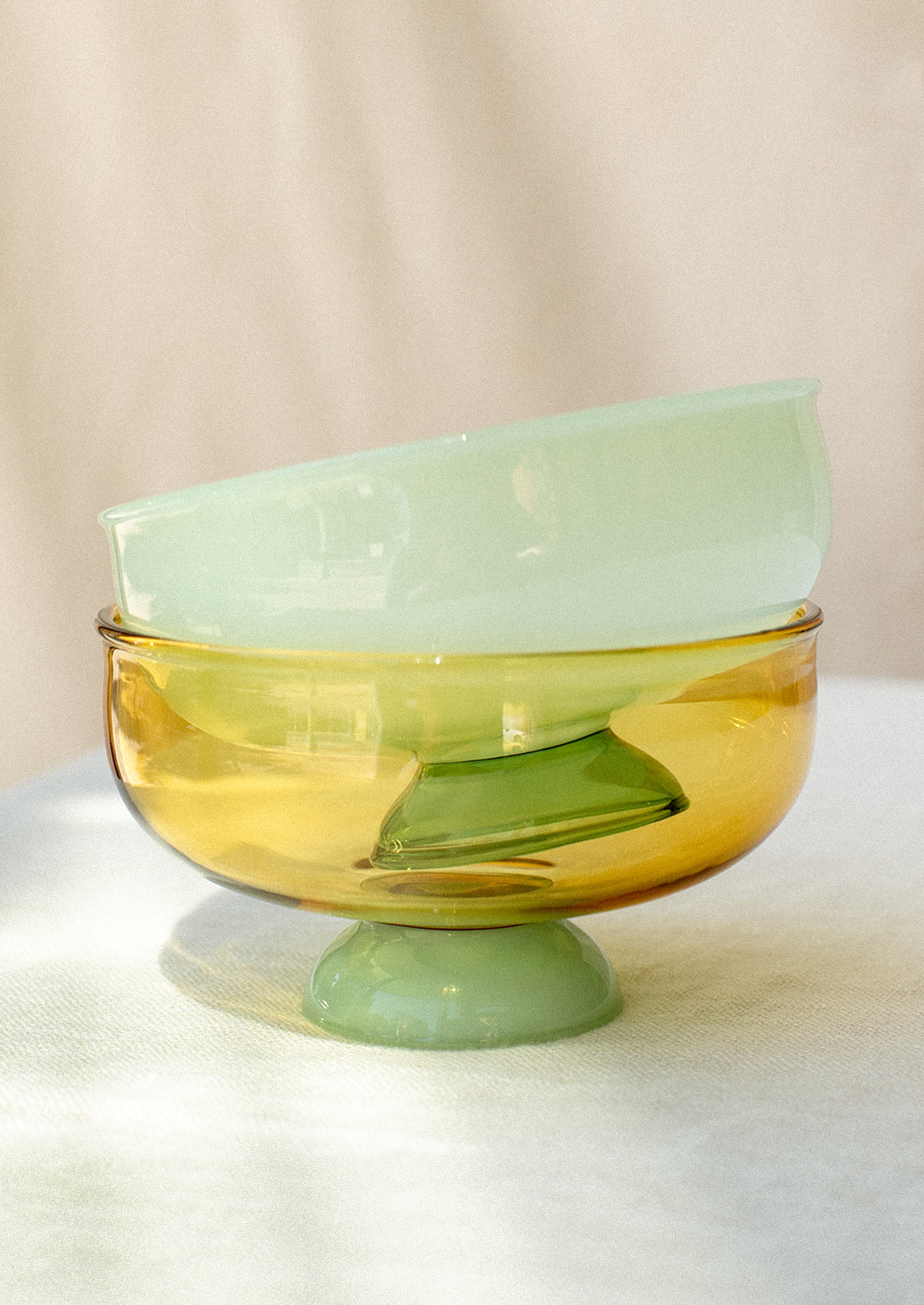 Shallow footed glass bowls in two tone colorways.