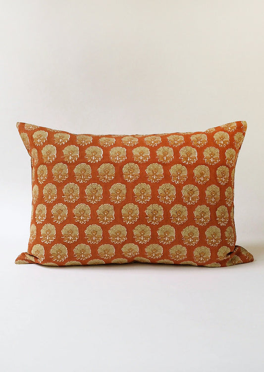 A rust and mossy green floral block print pillow.